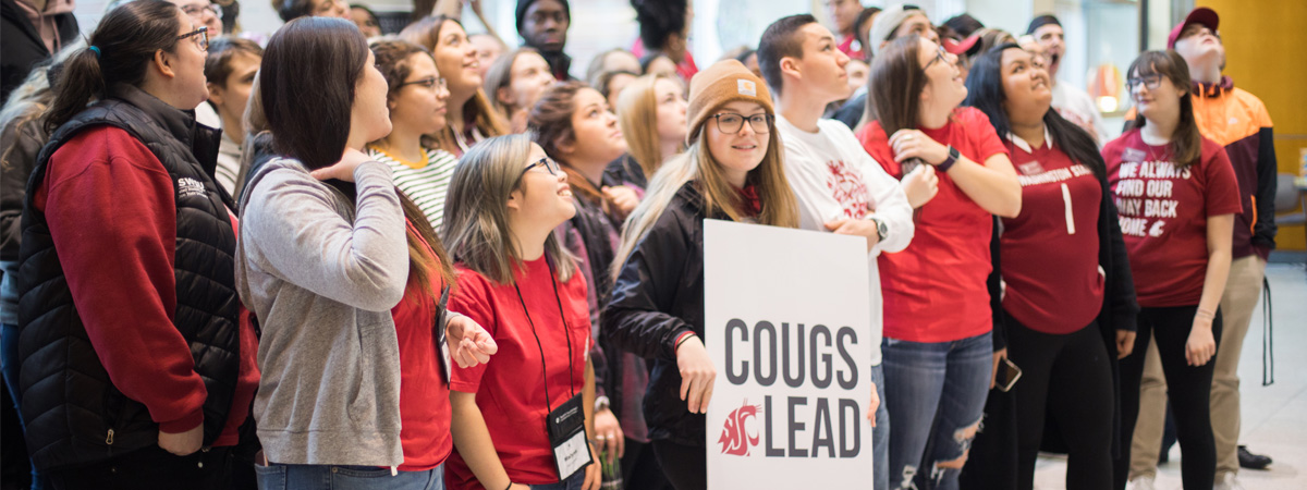 Group of student leaders holding a cougs lead sign